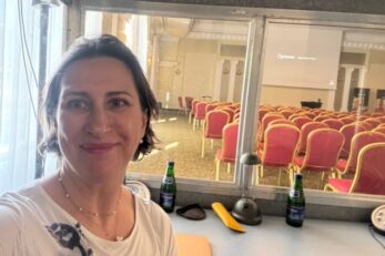 Tłumaczka w kabinie na konferencji o innowacjach na rynku aparatów słuchowych