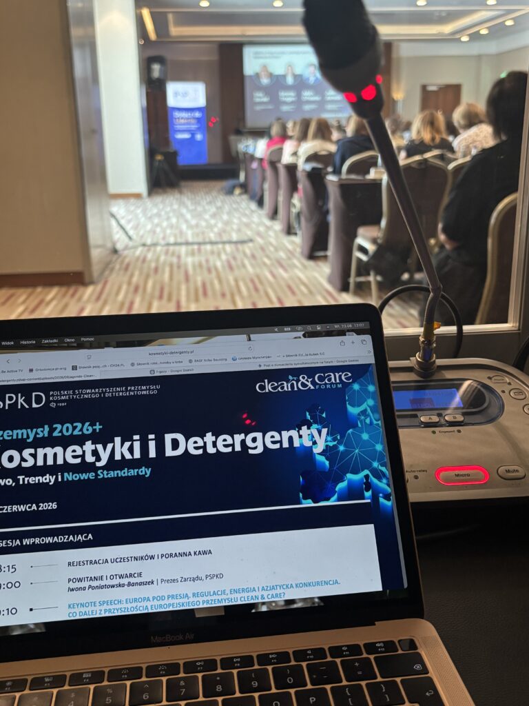 Sala Clean&Care Forum widziana z miejsca tłumacza - laptop i mikrofon na pierwszym planie, uczestnicy przed ekranem